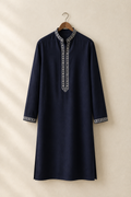 Deep navy embroidered kurta hanging on a wooden hanger against a warm studio wall